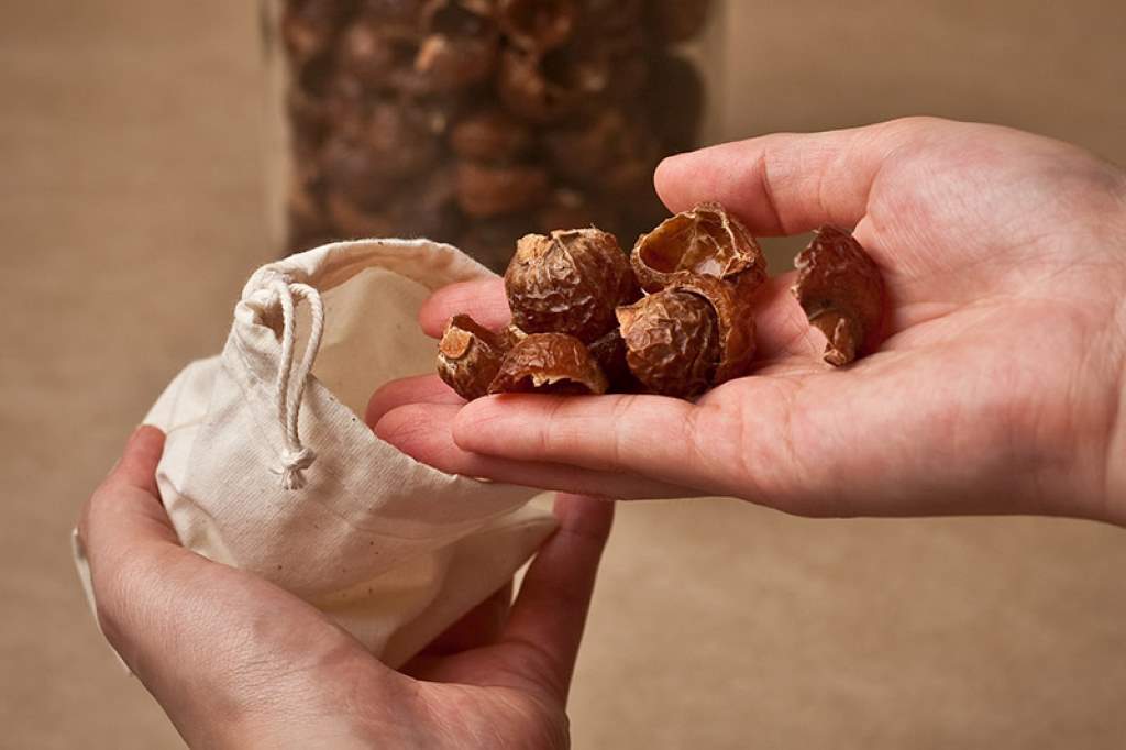 Soap nuts in a muslin bag on a washing machine.